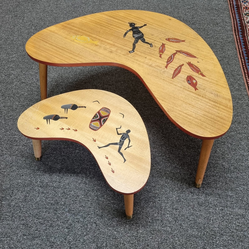 Australian Mid Century Coffee Tables by Indigenous Australians - Bill Onus, Aboriginal Enterprises, c.1960. The larger table depicts the Gunbalanya story of Buppa Piebi. The following inscription is written around the edge of the table: Bibr Bibr sees Buppa Piebi as he walks through the waterhole catching all the fish. But Margi, the man of magic, seizes Buppa's mela bag and says 